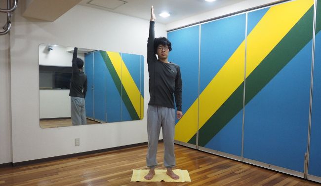 息を吐きながら円を描くように腕をまわし、地面と垂直になったところでとめます。

