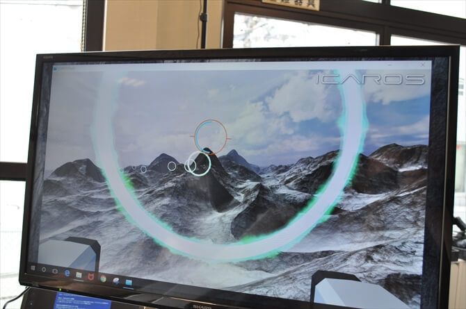 GRAM GYM::体験者がみている光景は、マシン隣のモニターで確認することが可能。1ゲーム5分間、進行方向のリングをくぐり抜けて、ゴールを目指します。