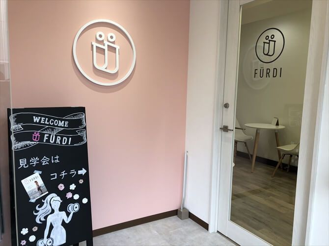 [女性専用] 新感覚のAI×フィットネス　ファディー 千歳烏山::ビルの1階、淡いピンクを基調とした女性的な印象のエントランスです。