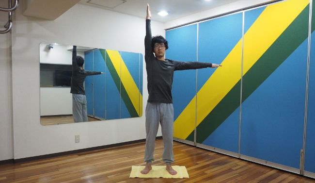 息を吸いながら、伸ばした手と反対の手も地面と平行に広げます。

