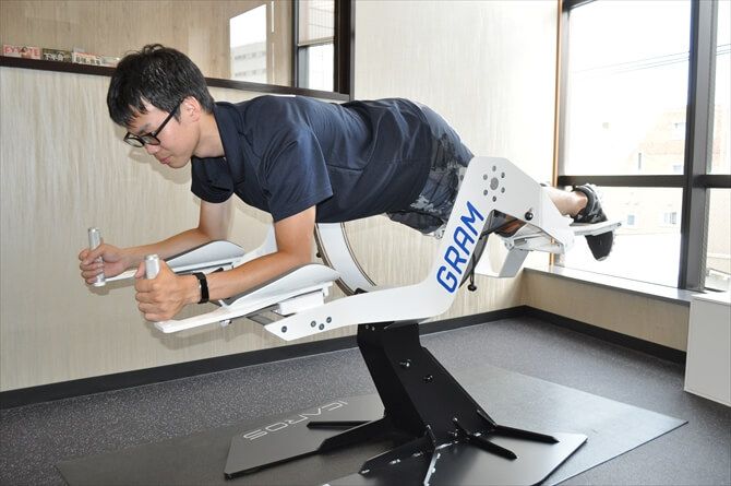 GRAM GYM::肘の位置と膝の位置を同じ高さにするのが基本姿勢。プログラム中のコントロールは、グリップのボタンとともに全身のバランス移動で行いますが、慣れないうちはお尻の位置を変えるように意識するとやりやすいとのこと。