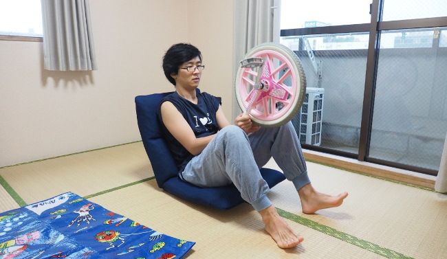 座椅子に座り、一輪車のサドルを腹筋にあてます。