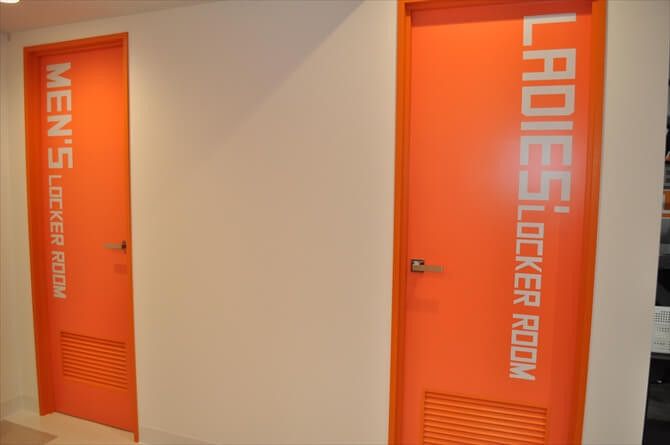 【パーソナルトレーニングジム】エクササイズコーチ銀座店::やる気を高めてくれる鮮やかなオレンジ色の扉のロッカールーム。