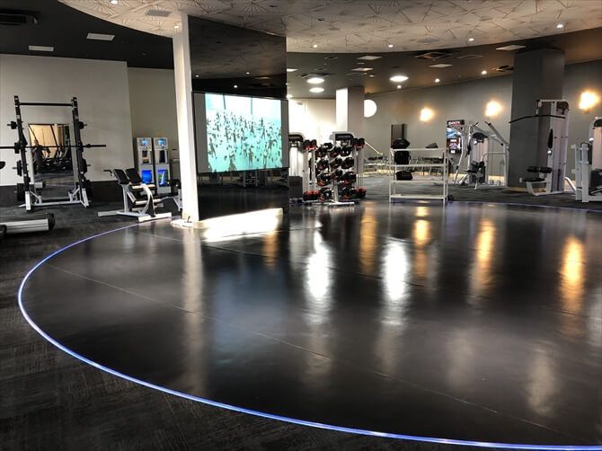 東急スポーツオアシス上大岡::夜間は照明が落とされ、クラブのような雰囲気に。インストラクター実演のプログラムのほか、大きなモニターに映し出されるバーチャルなプログラムも提供されます。